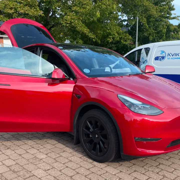 Rød Tesla efter udvendig bilvask med Kvik Bilplejes servicebil i baggrunden